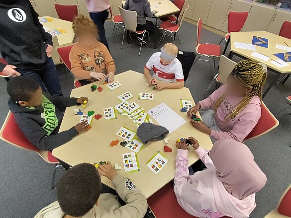 Kinder knobelnd am Gruppentisch 1